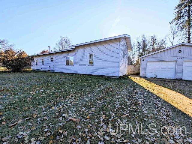 view of property exterior with a garage and a lawn