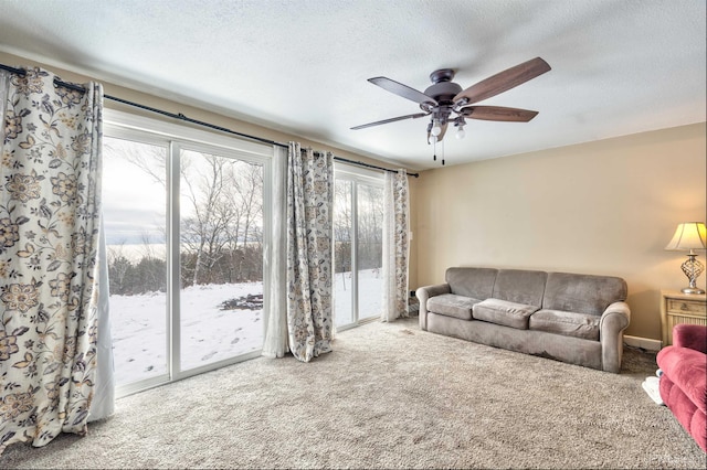 living room featuring carpet flooring, a textured ceiling, and ceiling fan