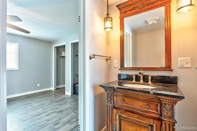 bathroom with hardwood / wood-style floors, vanity, and ceiling fan