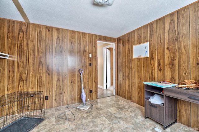 unfurnished office with wooden walls and a textured ceiling