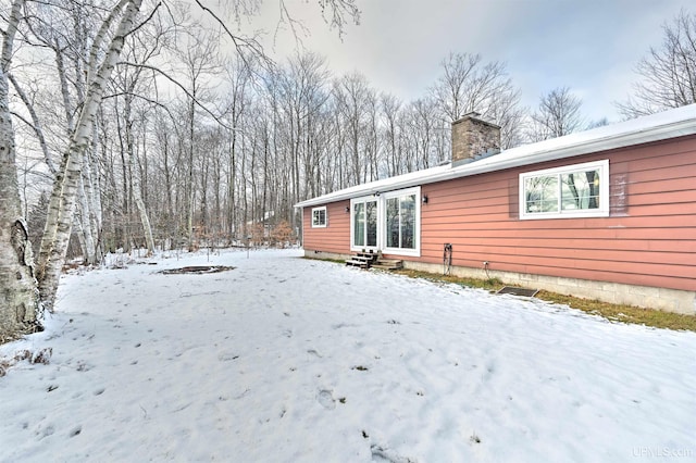 view of snow covered rear of property