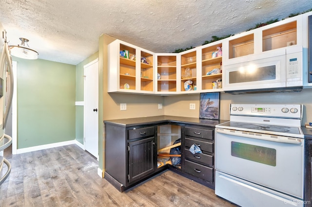 kitchen featuring a textured ceiling, white appliances, and light hardwood / wood-style floors