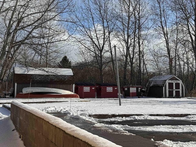 yard covered in snow featuring a shed