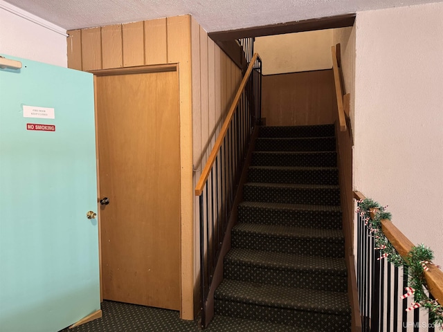 stairs featuring carpet and a textured ceiling