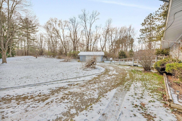 snowy yard featuring a garage and an outdoor structure