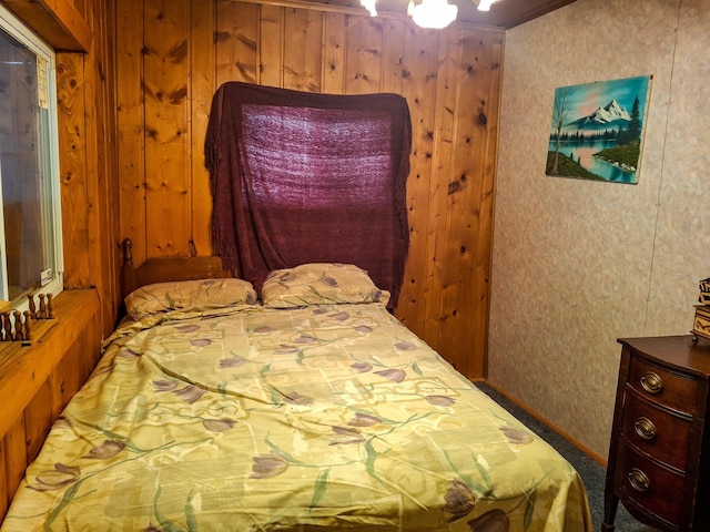 bedroom with ornamental molding and wooden walls