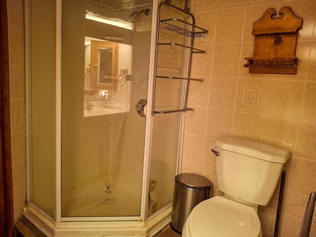 bathroom featuring toilet, tile walls, and walk in shower