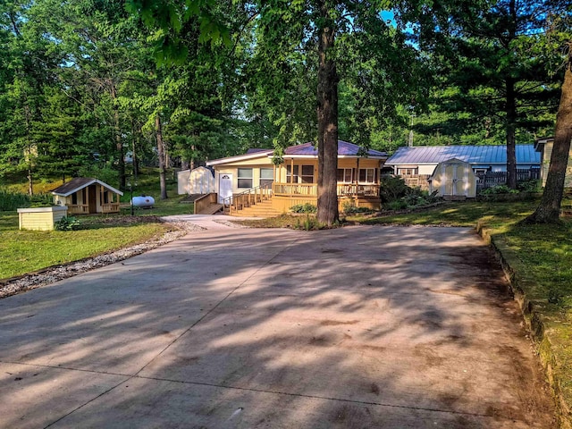 6741 Carpenter Rd, Harrison, MI 48625 - view of front facade featuring a porch, concrete driveway, and a front yard