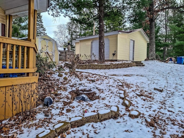 yard covered in snow with a storage unit