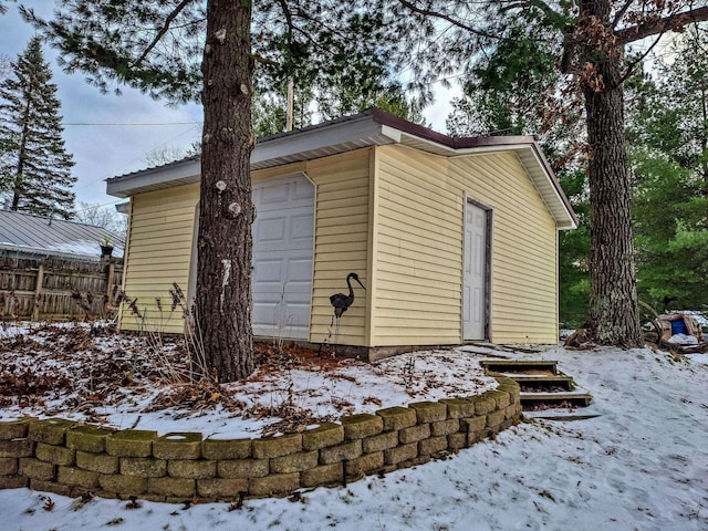 snow covered structure featuring a garage