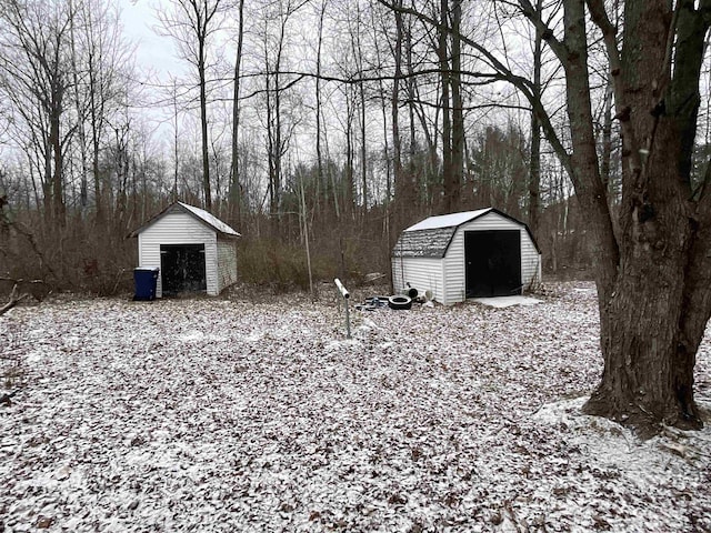 yard layered in snow featuring a shed