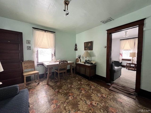 office area with dark colored carpet and a wealth of natural light