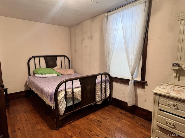 bedroom with dark hardwood / wood-style flooring