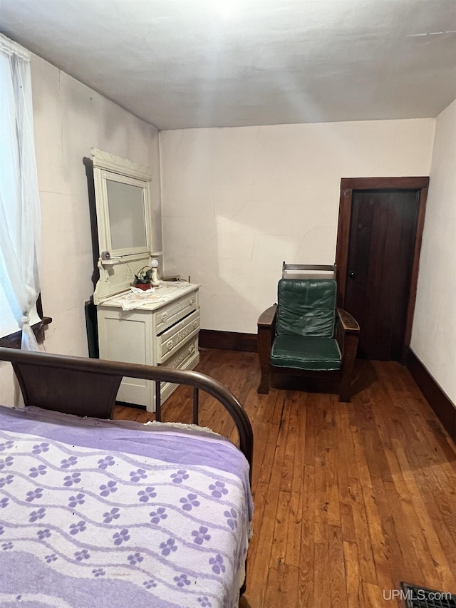 bedroom with dark wood-type flooring