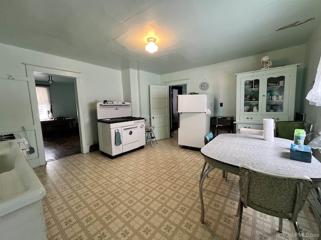 kitchen featuring white cabinets and white appliances