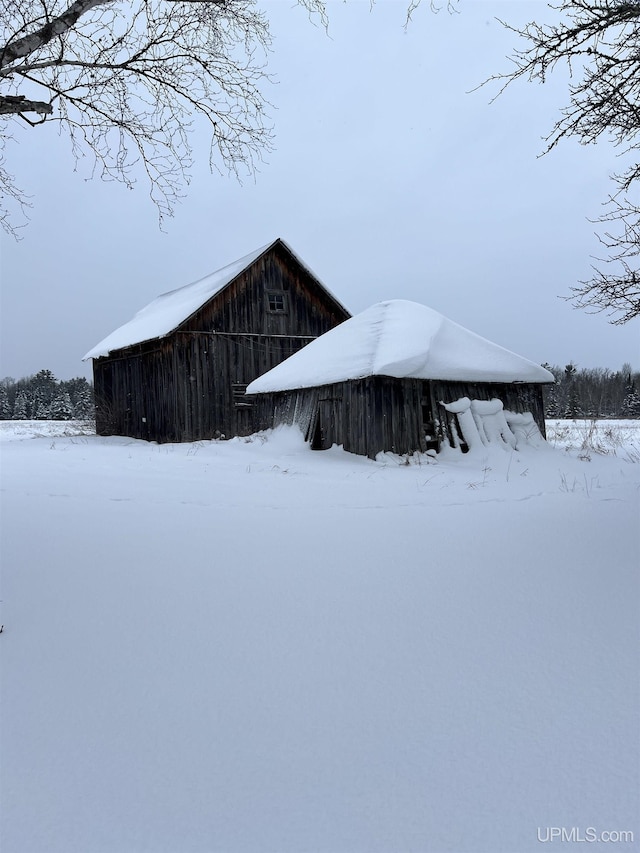 view of snowy exterior with an outbuilding