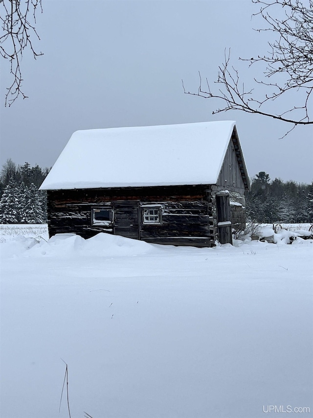 view of snowy exterior with an outbuilding