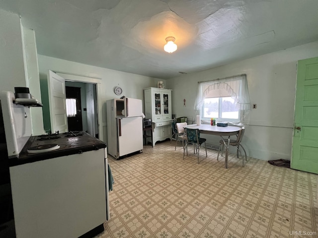 kitchen featuring white cabinetry and white fridge