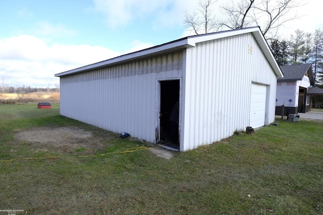 view of outdoor structure featuring a lawn and a garage