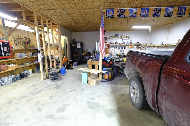 garage with a workshop area and water heater