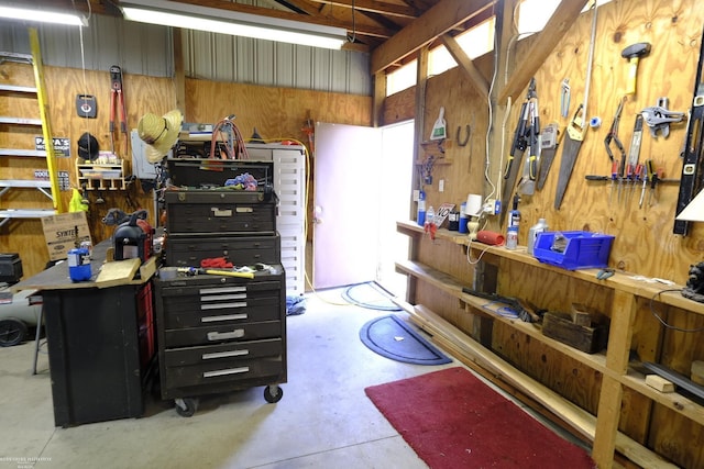 garage with a workshop area and wood walls