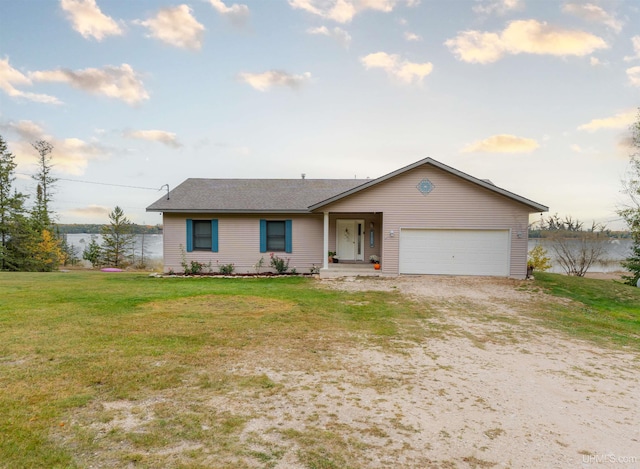 ranch-style house featuring a water view, a garage, and a front yard