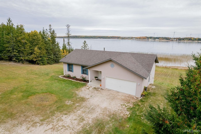 single story home with a front lawn, a water view, and a garage