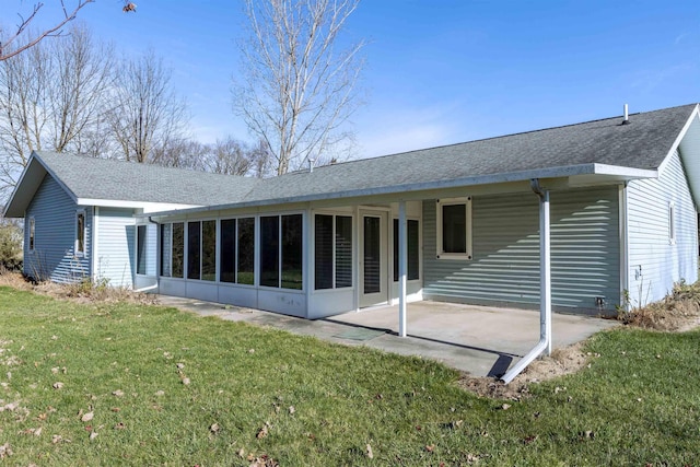 back of property featuring a sunroom, a patio area, and a lawn