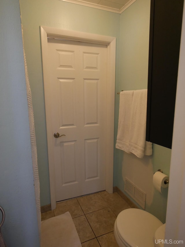 bathroom with toilet, tile patterned flooring, and ornamental molding