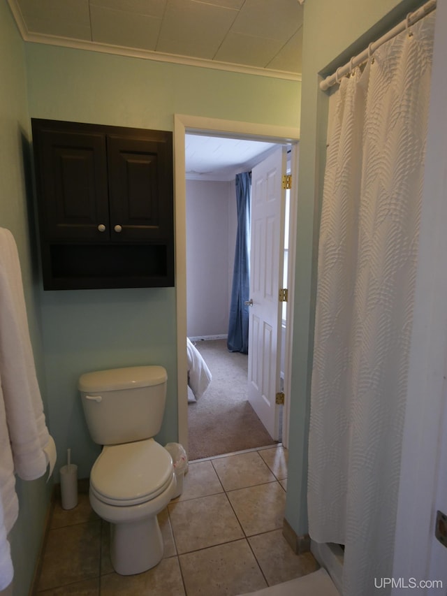 bathroom with toilet, tile patterned floors, and ornamental molding