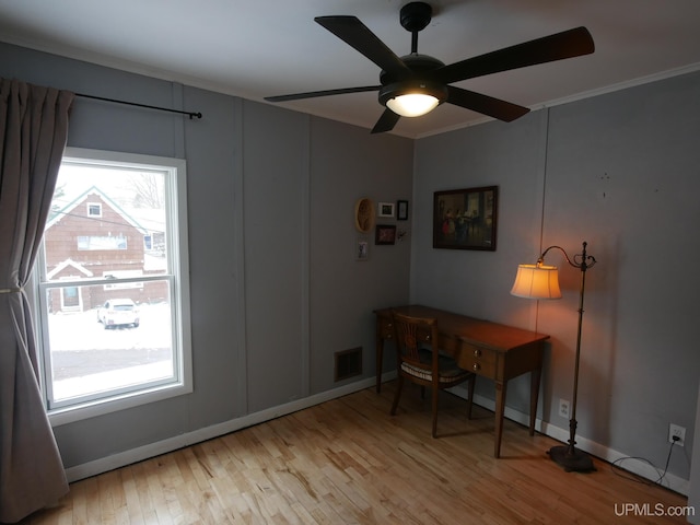 home office featuring ceiling fan, light wood-type flooring, and crown molding