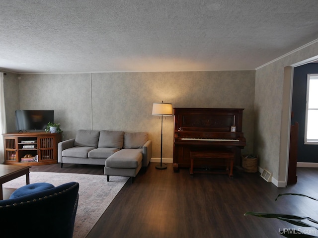 living room featuring a textured ceiling, dark hardwood / wood-style floors, and crown molding