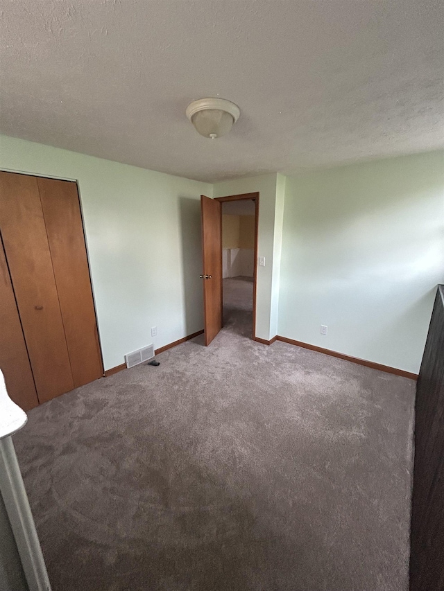 unfurnished bedroom featuring light carpet and a textured ceiling