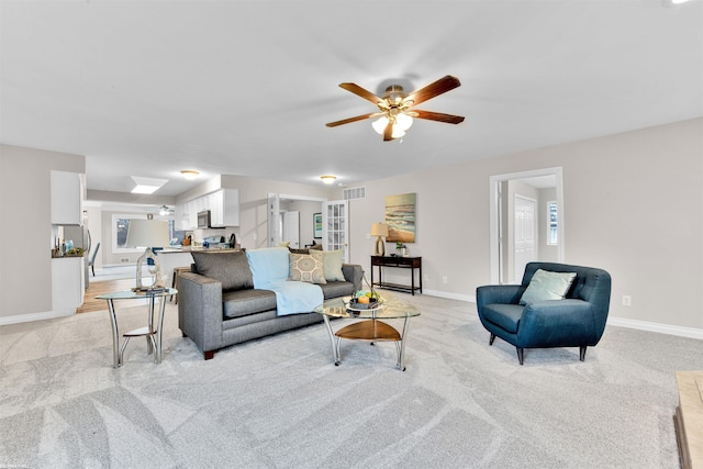 living room featuring ceiling fan, french doors, and light colored carpet