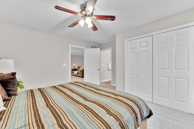 bedroom featuring ceiling fan, a closet, and light colored carpet