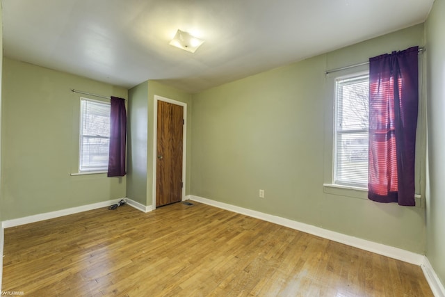 unfurnished room with plenty of natural light and hardwood / wood-style flooring