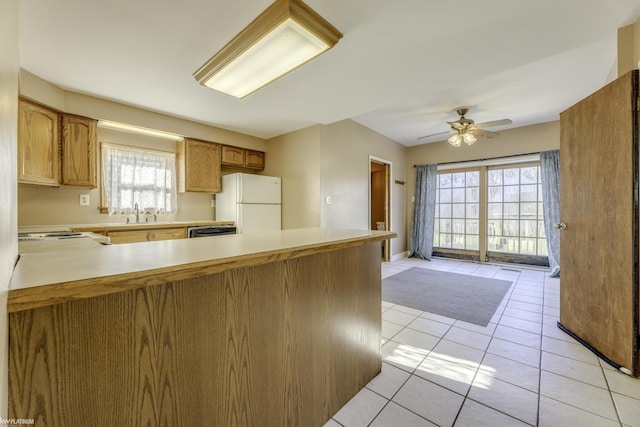 kitchen with white appliances, sink, ceiling fan, light tile patterned floors, and kitchen peninsula