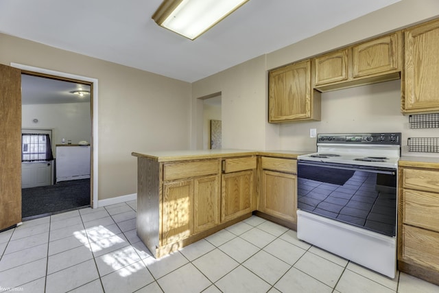 kitchen featuring white range with electric stovetop, light tile patterned floors, and kitchen peninsula