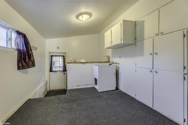 laundry area with dark colored carpet