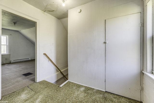 stairway featuring carpet flooring, vaulted ceiling, and a baseboard heating unit