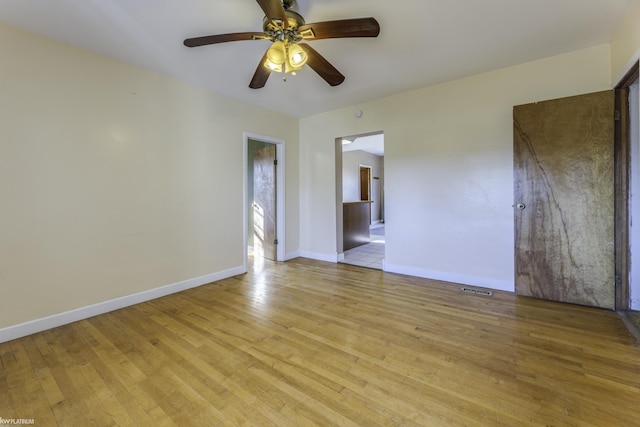 empty room with ceiling fan and light hardwood / wood-style floors