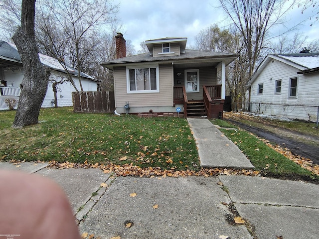 bungalow-style house with covered porch and a front yard