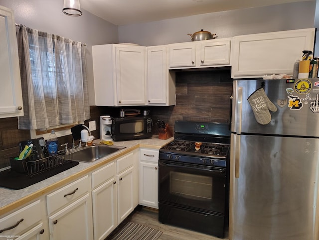 kitchen with sink, tasteful backsplash, white cabinetry, and black appliances