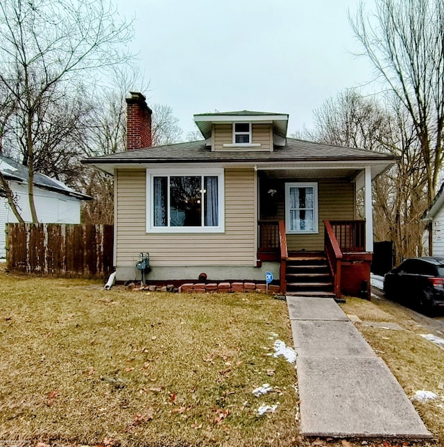 bungalow-style home with covered porch and a front lawn