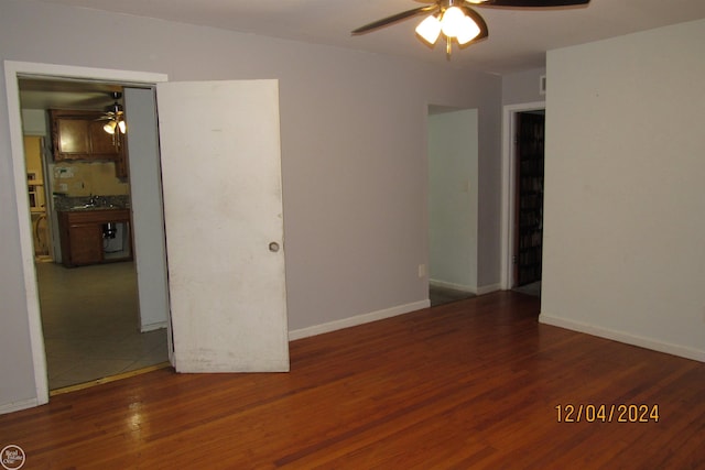 empty room featuring ceiling fan, sink, and dark wood-type flooring