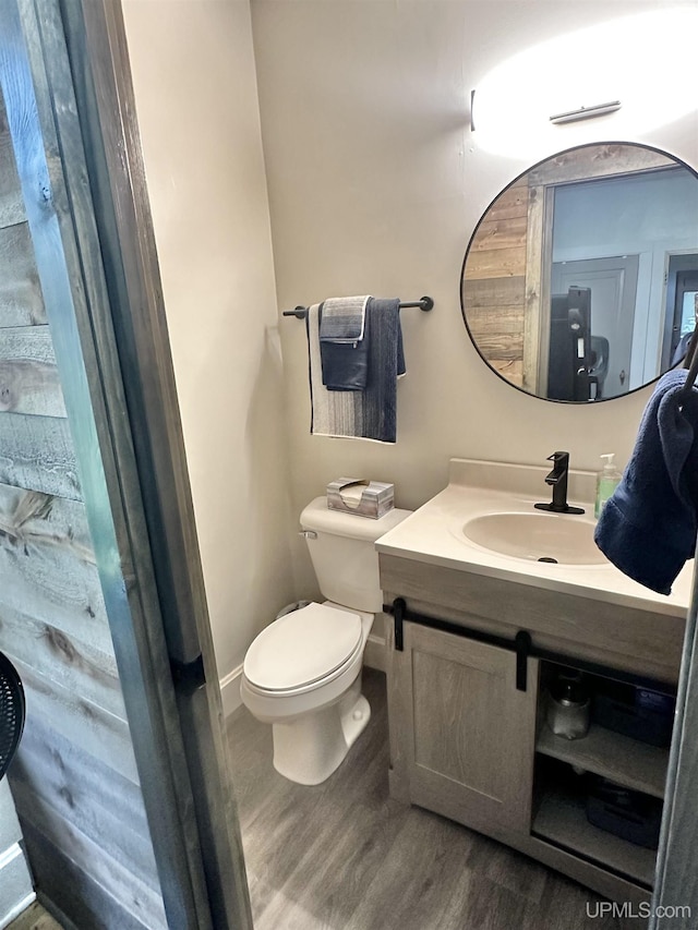 bathroom with toilet, vanity, and hardwood / wood-style flooring