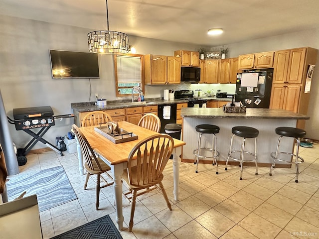 kitchen featuring sink, an inviting chandelier, pendant lighting, a kitchen island, and black appliances