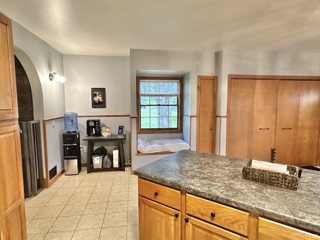 kitchen with dark stone countertops and light tile patterned floors