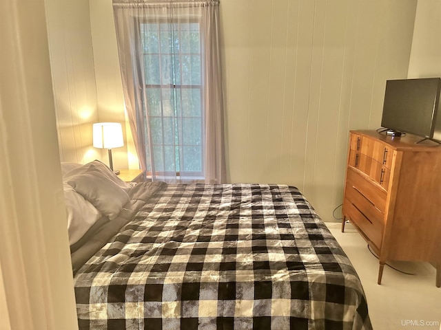 bedroom with wooden walls and multiple windows