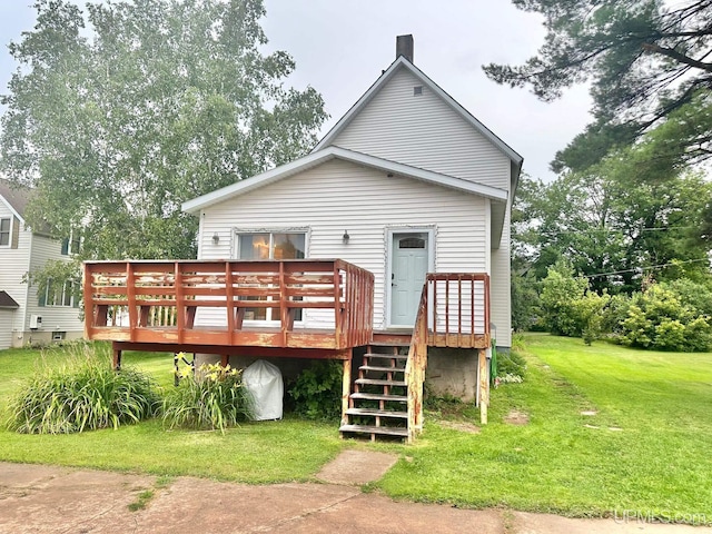 rear view of property featuring a yard and a wooden deck